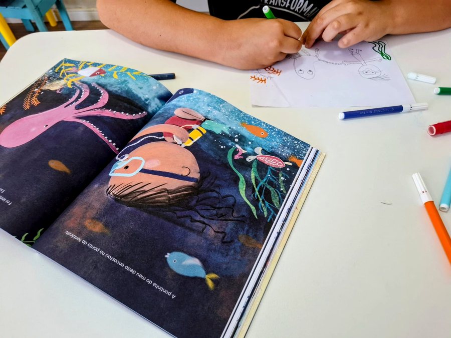 Livro ilustrado e desenho em produção durante uma atividade real da clínica