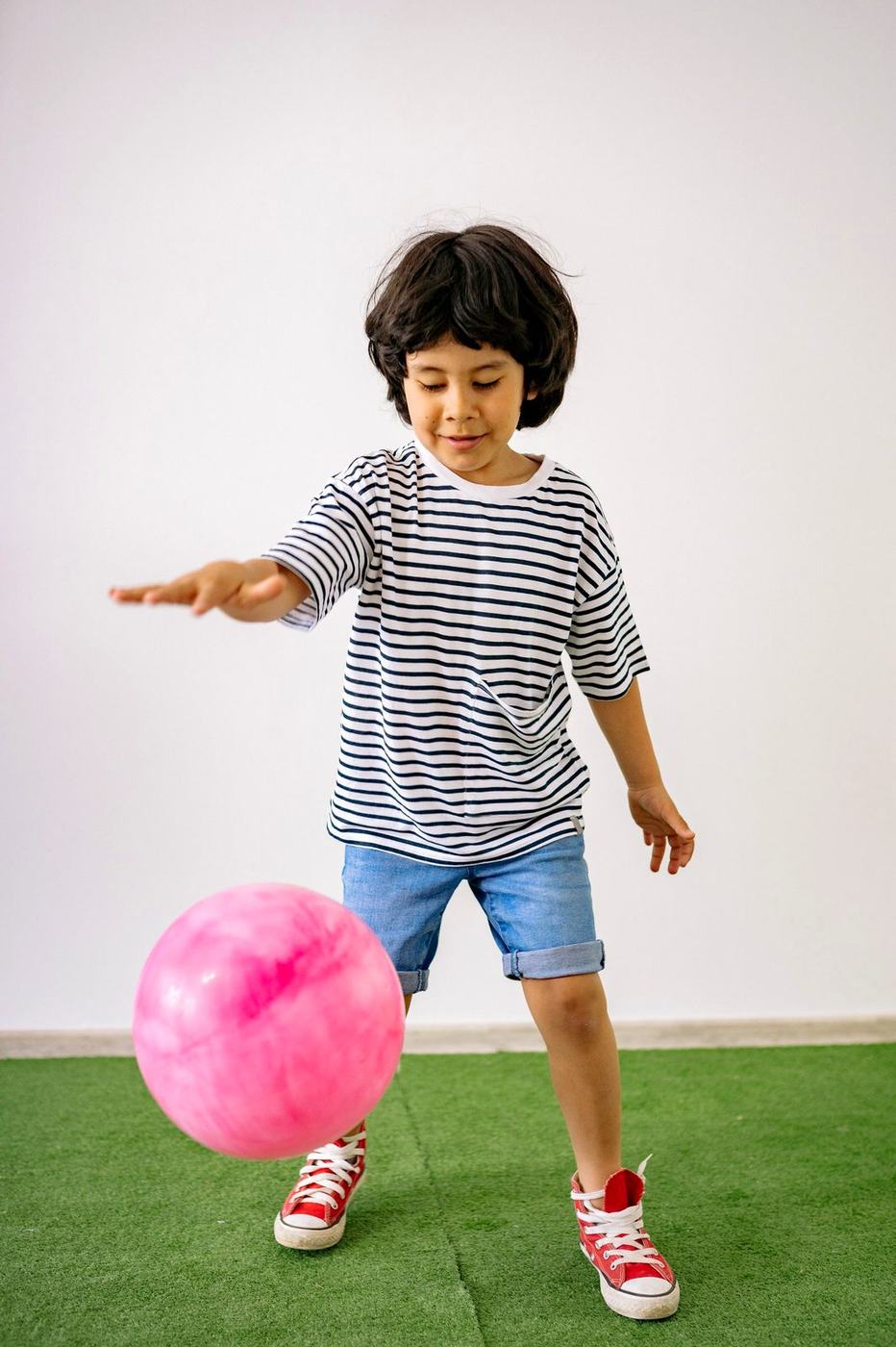 Menino brincando com uma bola, em movimento